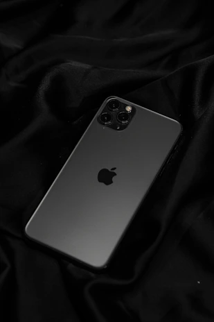 A sleek black iPhone with a minimalist premium case on a dark background.