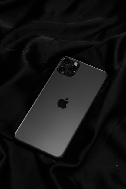 A sleek black iPhone with a minimalist premium case on a dark background.