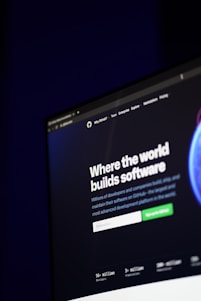 A computer screen displays a website with the text 'Where the world builds software' prominently featured. Below the text, there are fields for users to input their email address, along with additional descriptions about the platform and its capabilities. The website has a dark background with bright text, indicating a professional tech-based service.