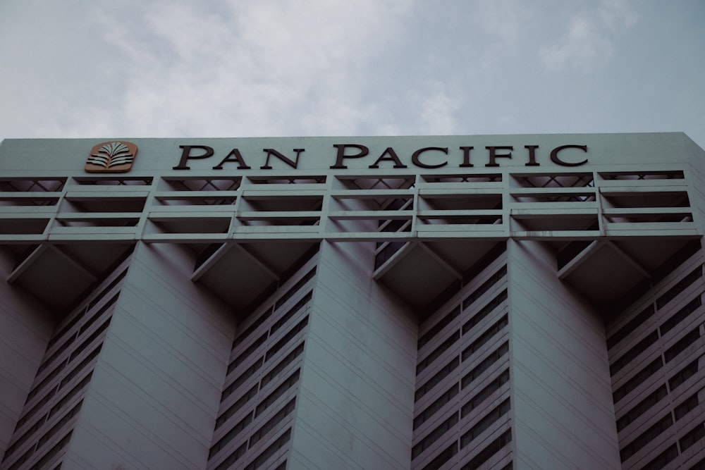 low angle photography of gray concrete building under white clouds during daytime