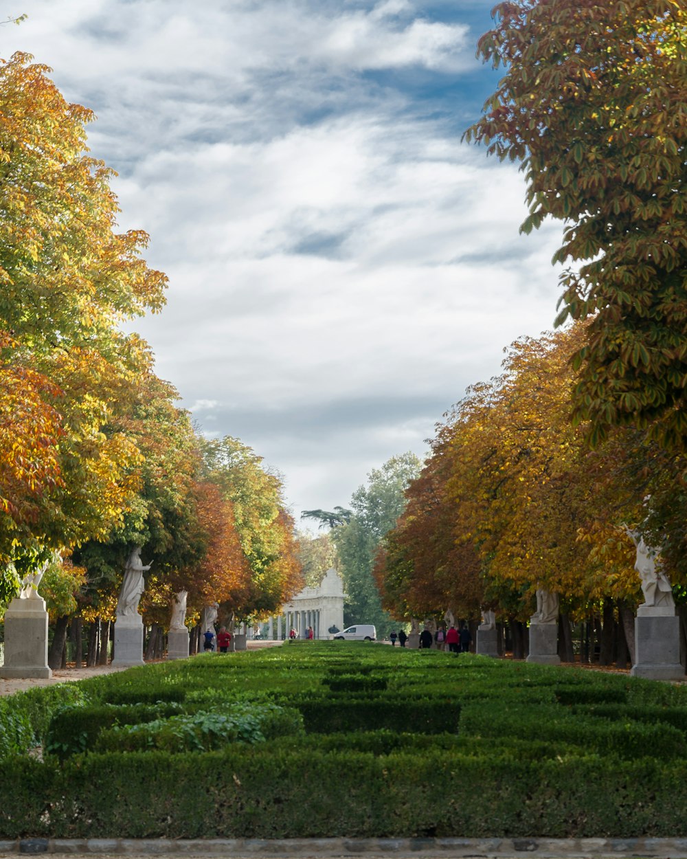 green grass field with trees and white concrete building