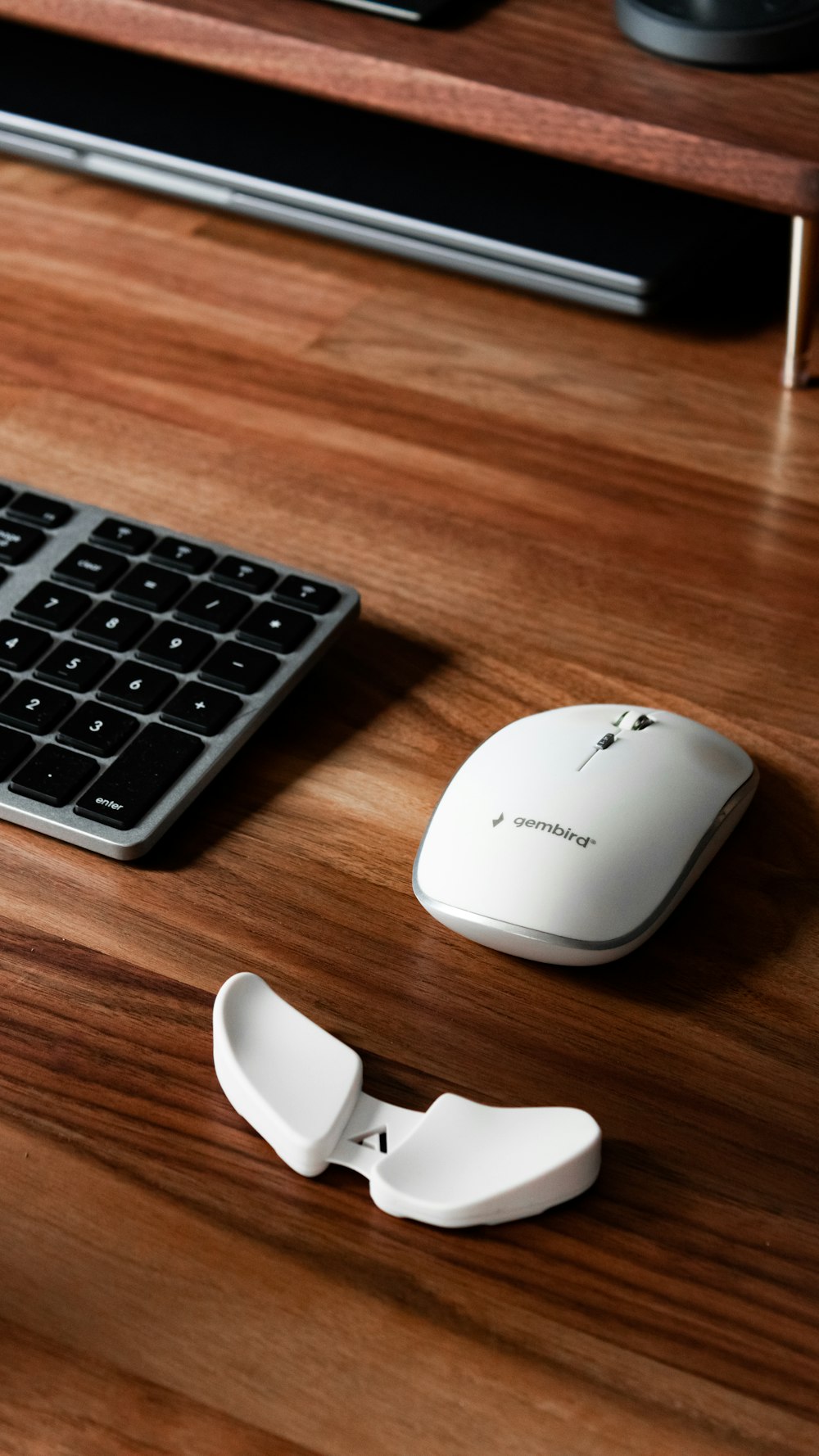 white and gray wireless computer mouse on brown wooden table