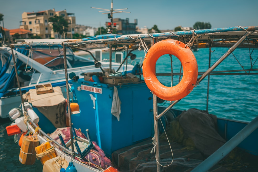 orange life buoy on blue and white boat during daytime