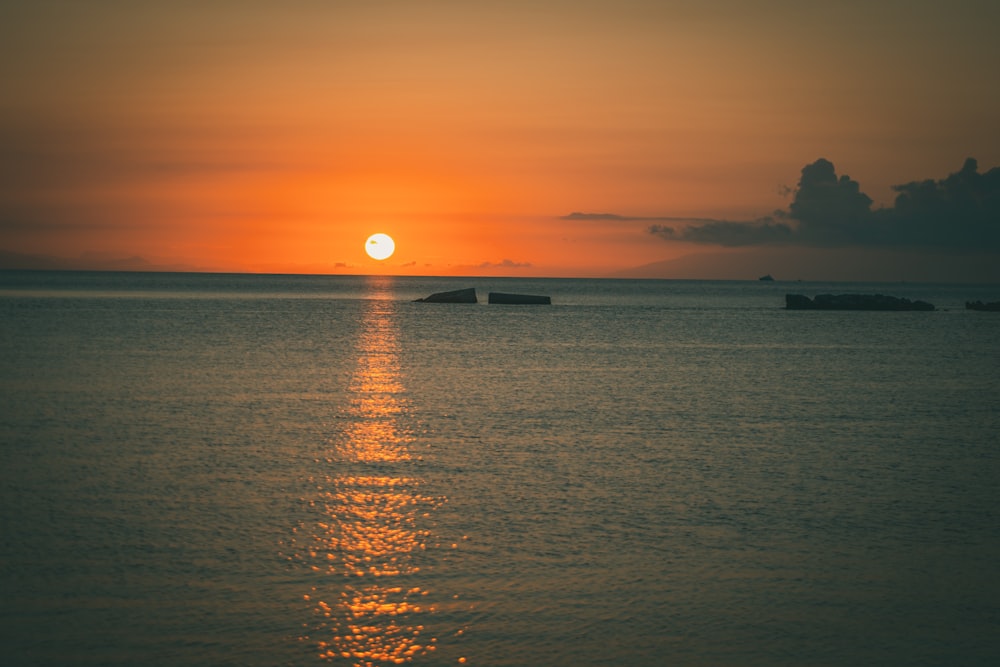 silhouette of boat on sea during sunset