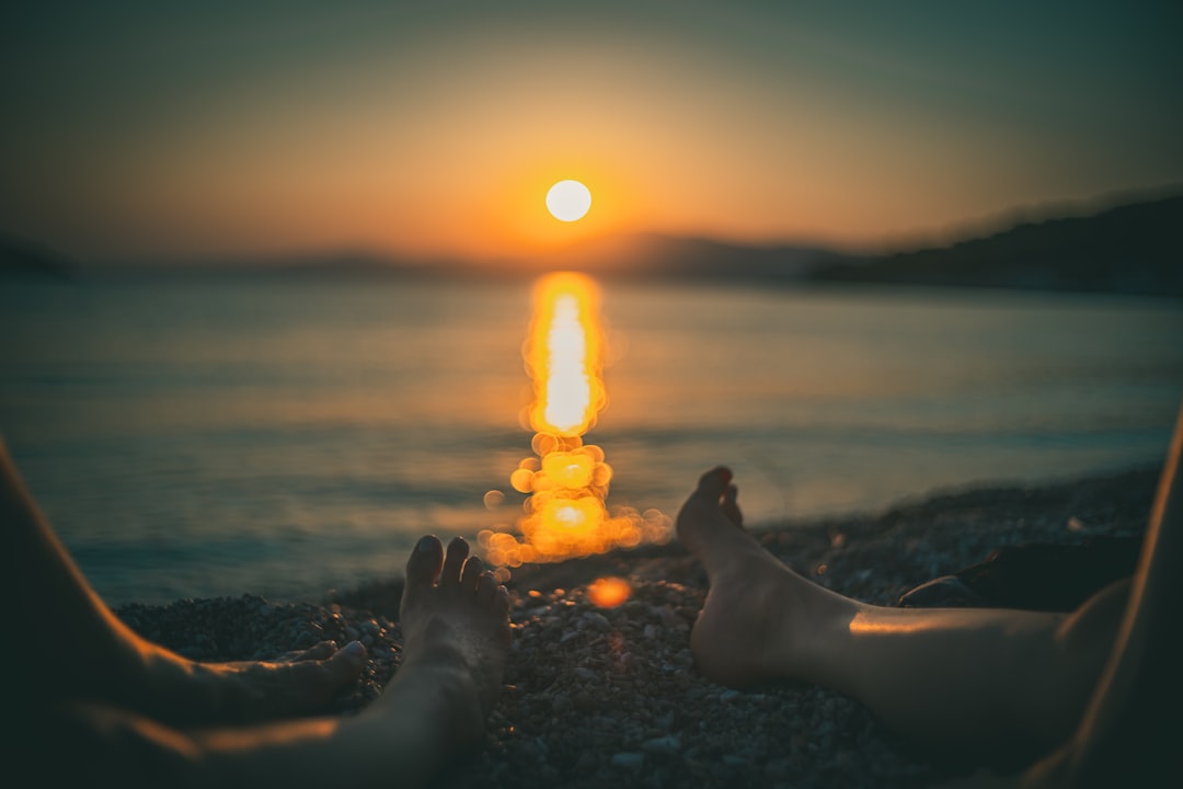 person lying on the ground with lighted candles during sunset