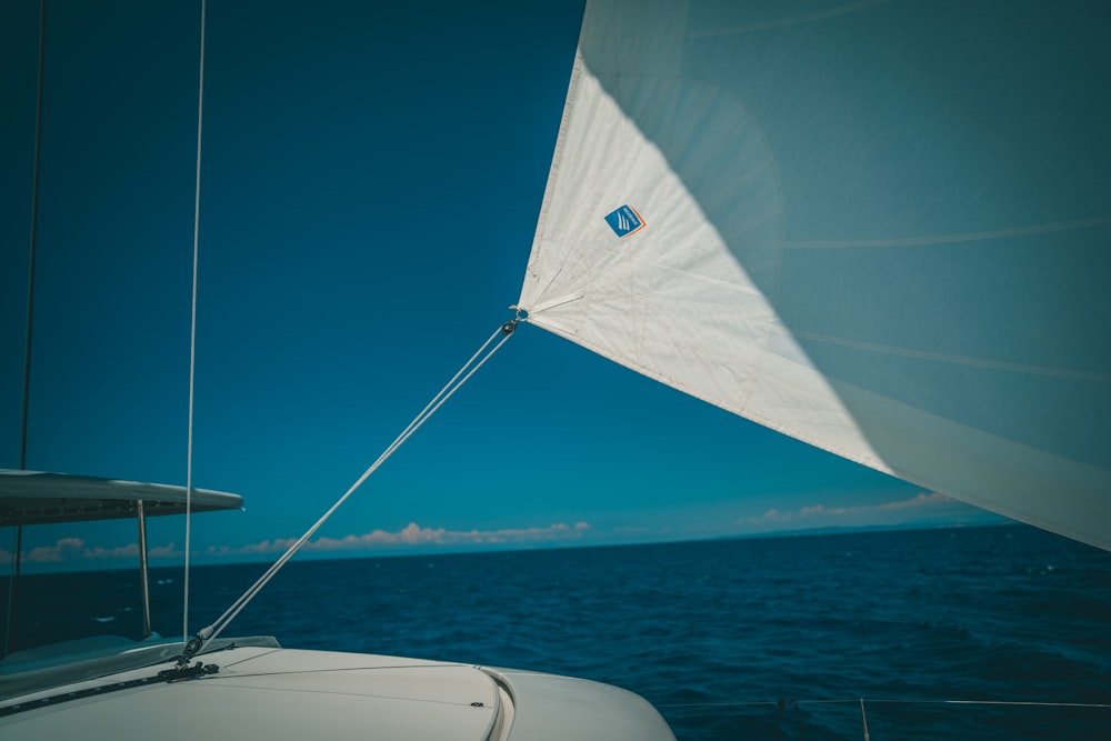 white sailboat on sea under blue sky during daytime