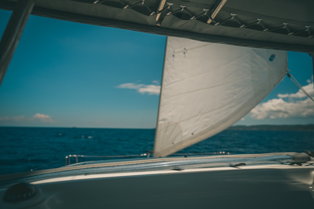 white sailboat on sea under blue sky during daytime