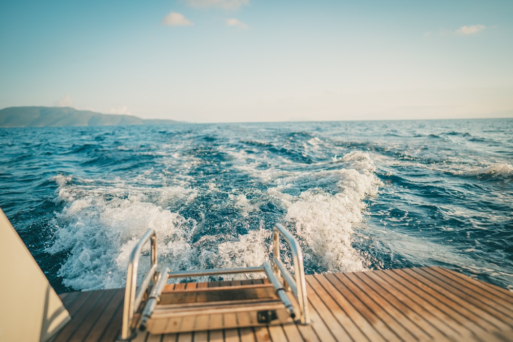 昼間の青い海に浮かぶ茶色の木造船着こし