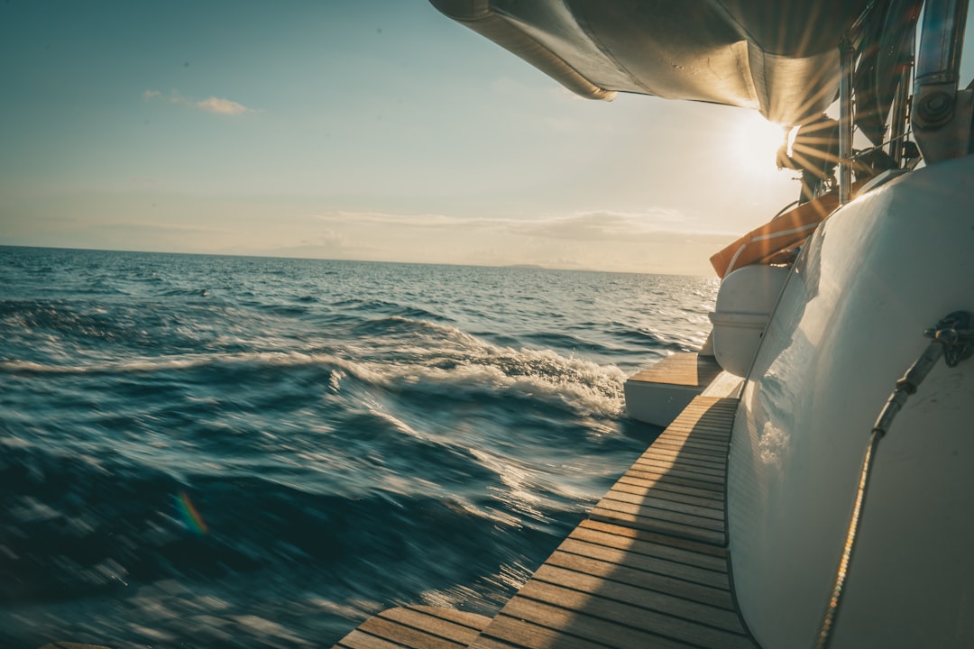 person in white dress shirt standing on brown wooden dock during daytime