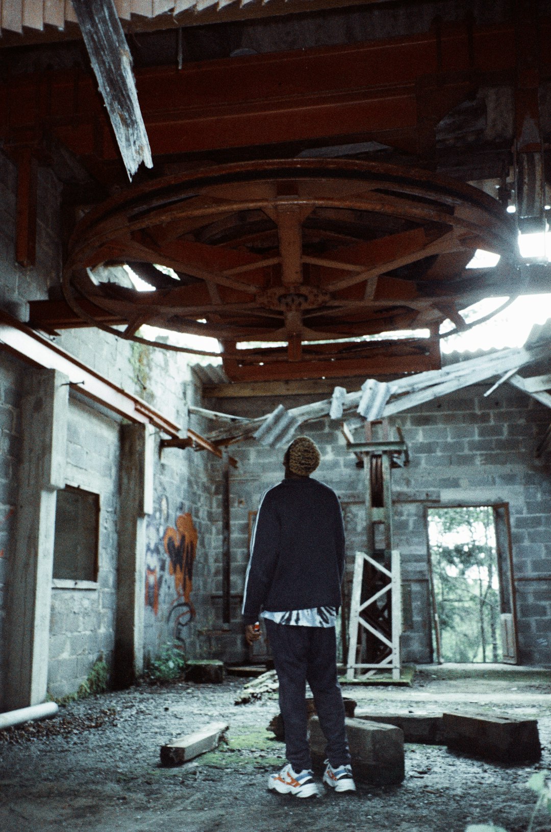 man in black jacket standing in front of painting