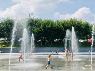 Happy families enjoying clean water at a community park fountain.