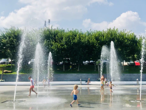 Happy families enjoying clean water at a community park fountain.
