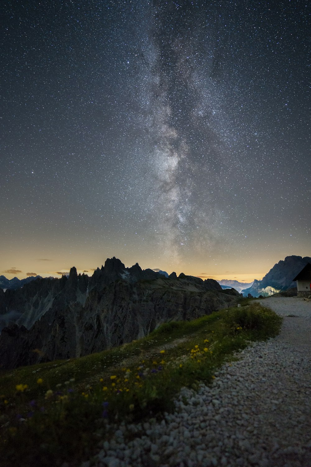 Campo de hierba verde cerca de la montaña bajo la noche estrellada