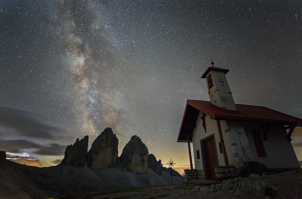 white and brown house near rocky mountain under starry night
