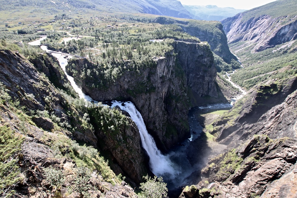 river between green and brown mountains during daytime