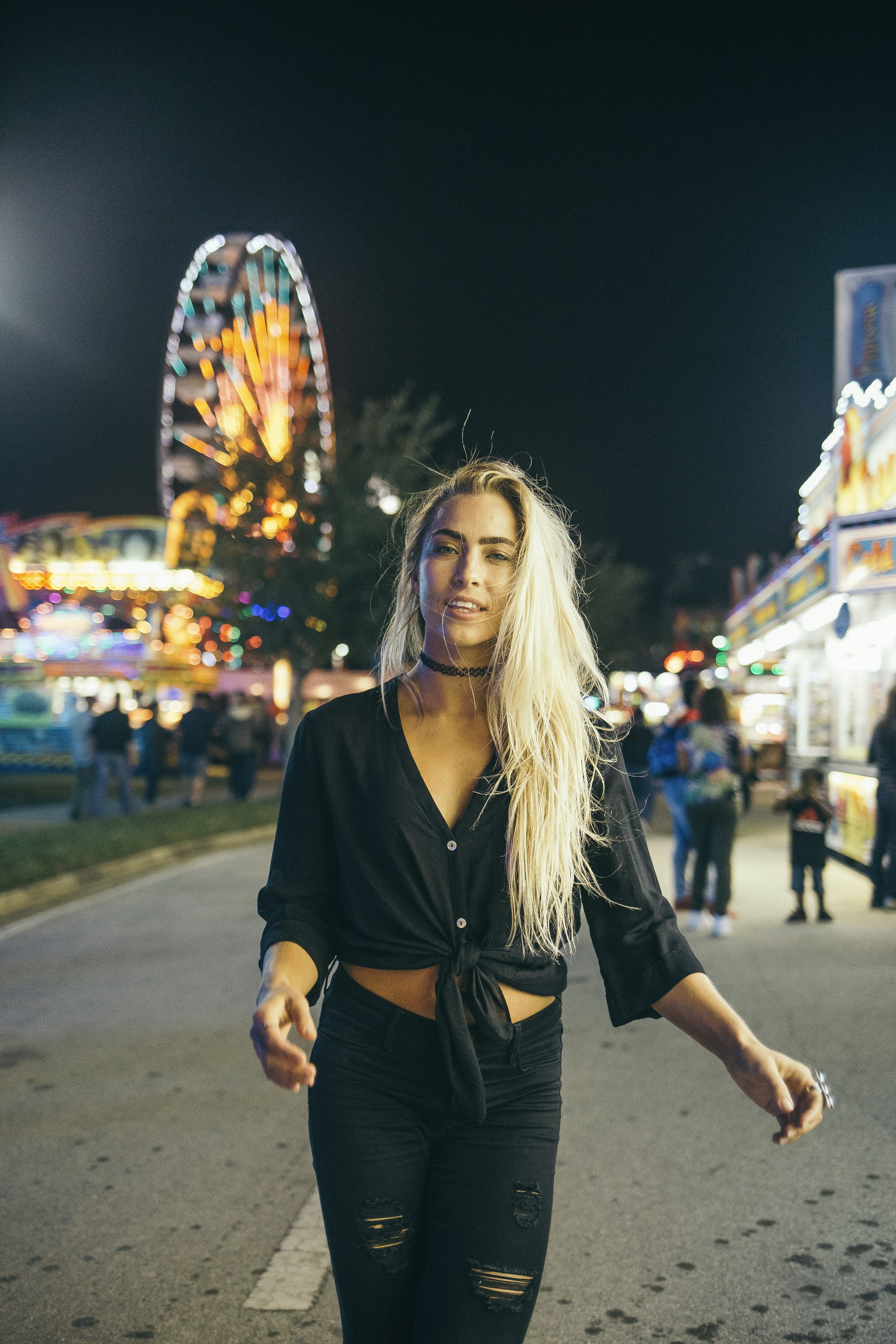 woman in black long sleeve shirt standing on street during nighttime