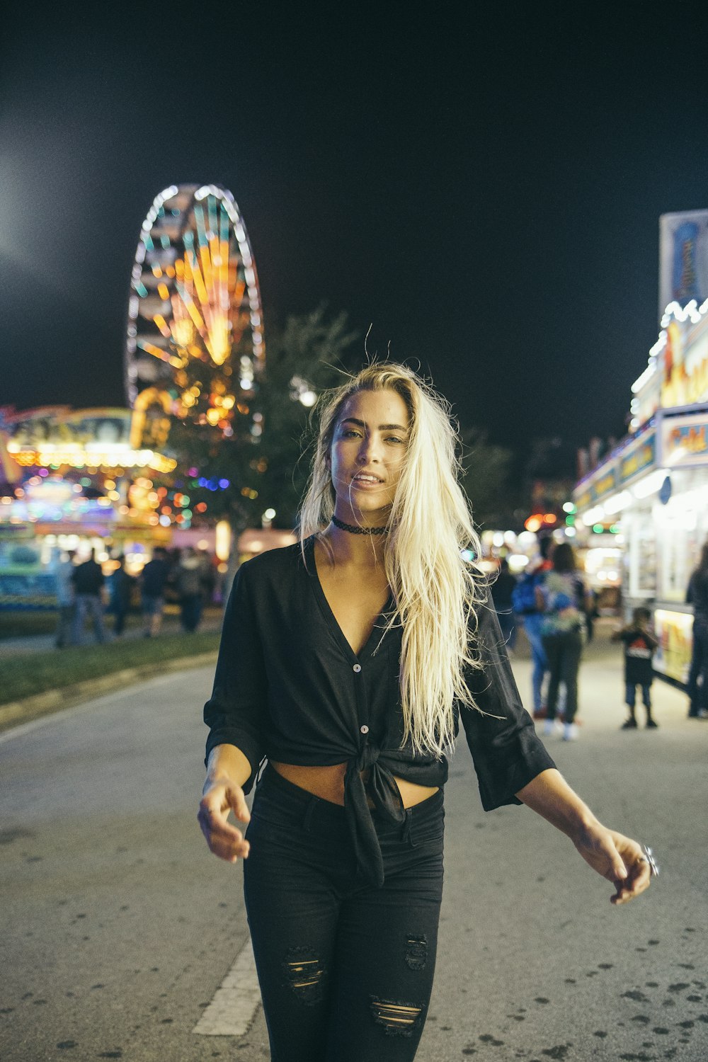 woman in black long sleeve shirt standing on street during nighttime