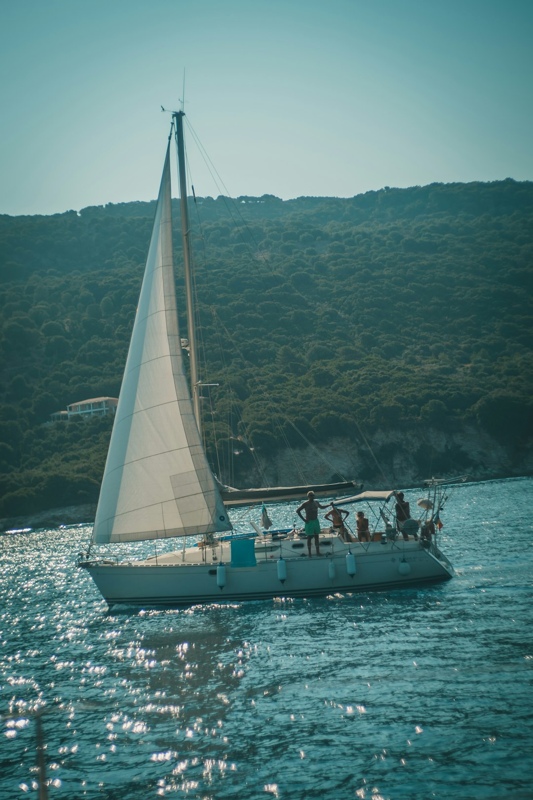 people riding on white and blue sail boat on sea during daytime
