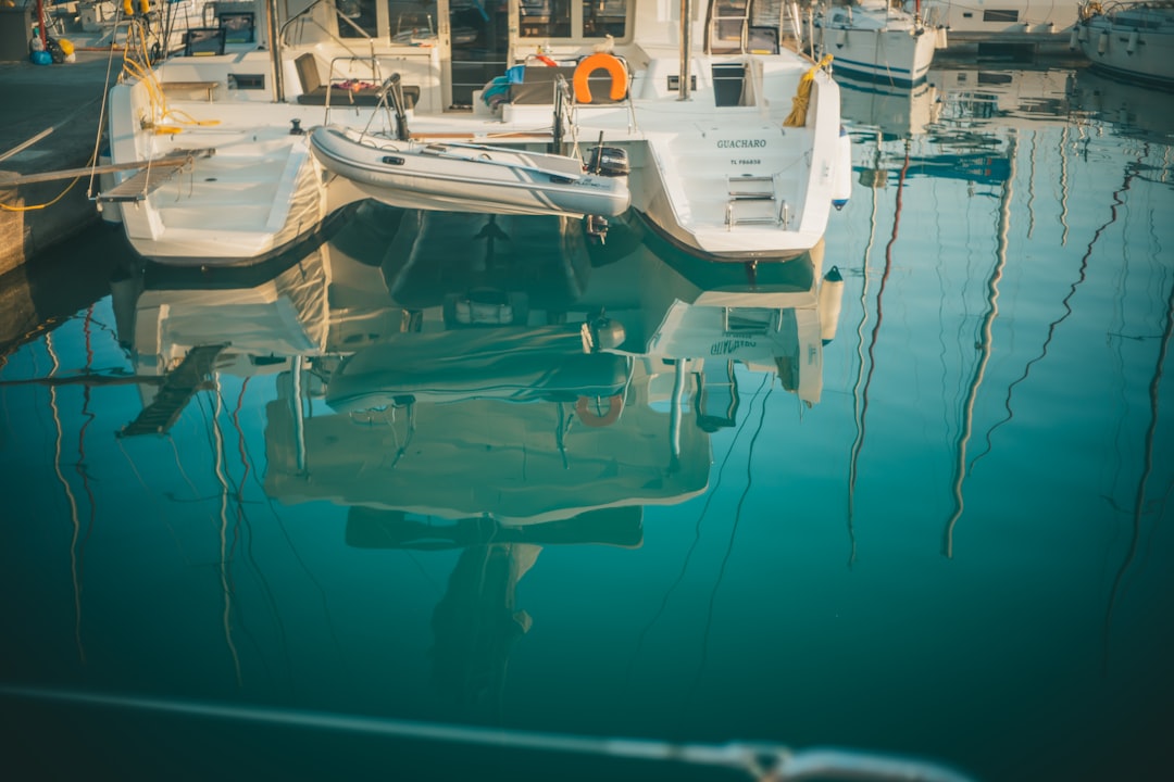 white and blue boat on body of water during daytime