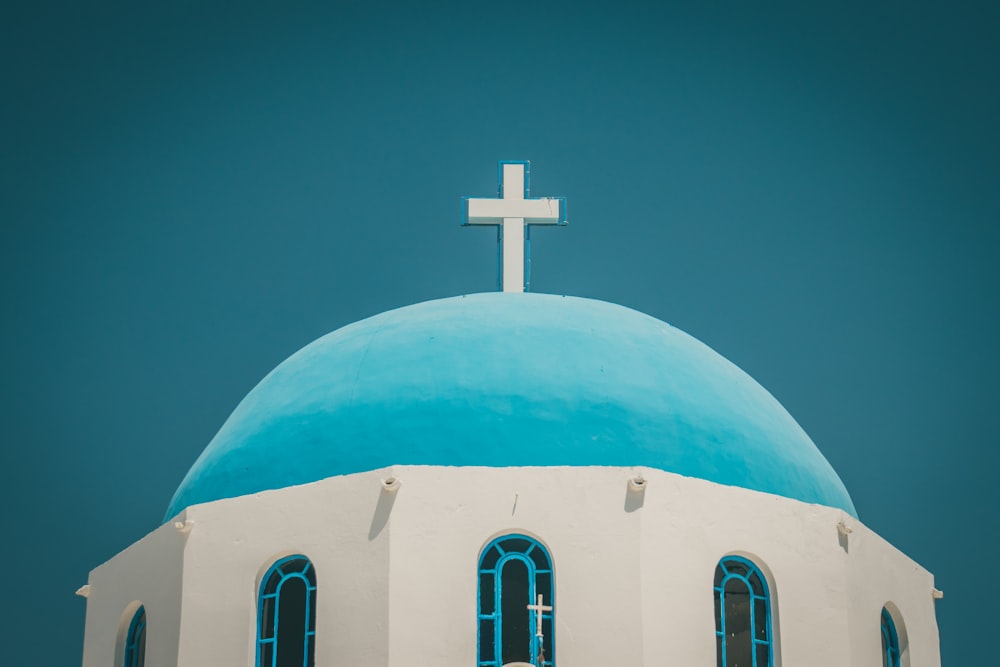 cruz blanca sobre techo de cúpula azul