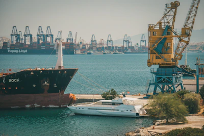 A panoramic view of a busy port with multiple vessels docked and crew coordinating operations.