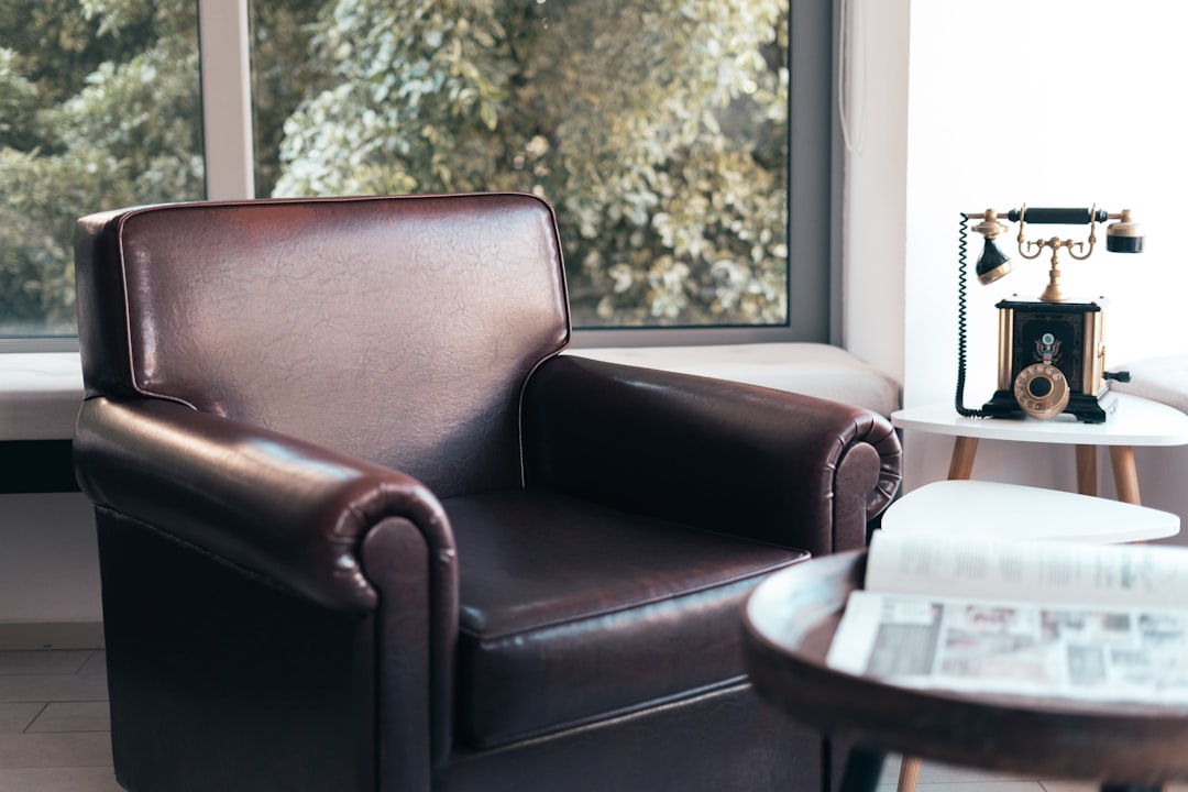 brown leather armchair beside white wooden table