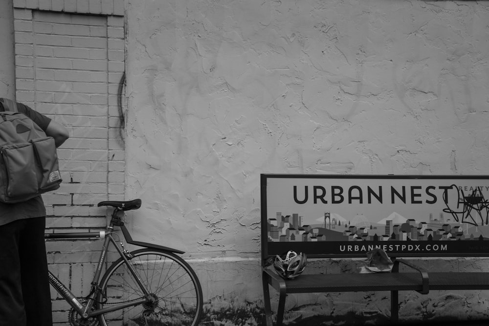 grayscale photo of bicycle beside wall