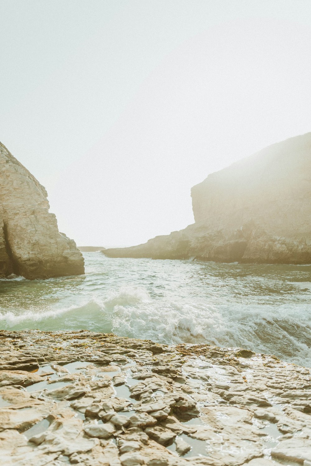 brown rocky mountain beside body of water during daytime