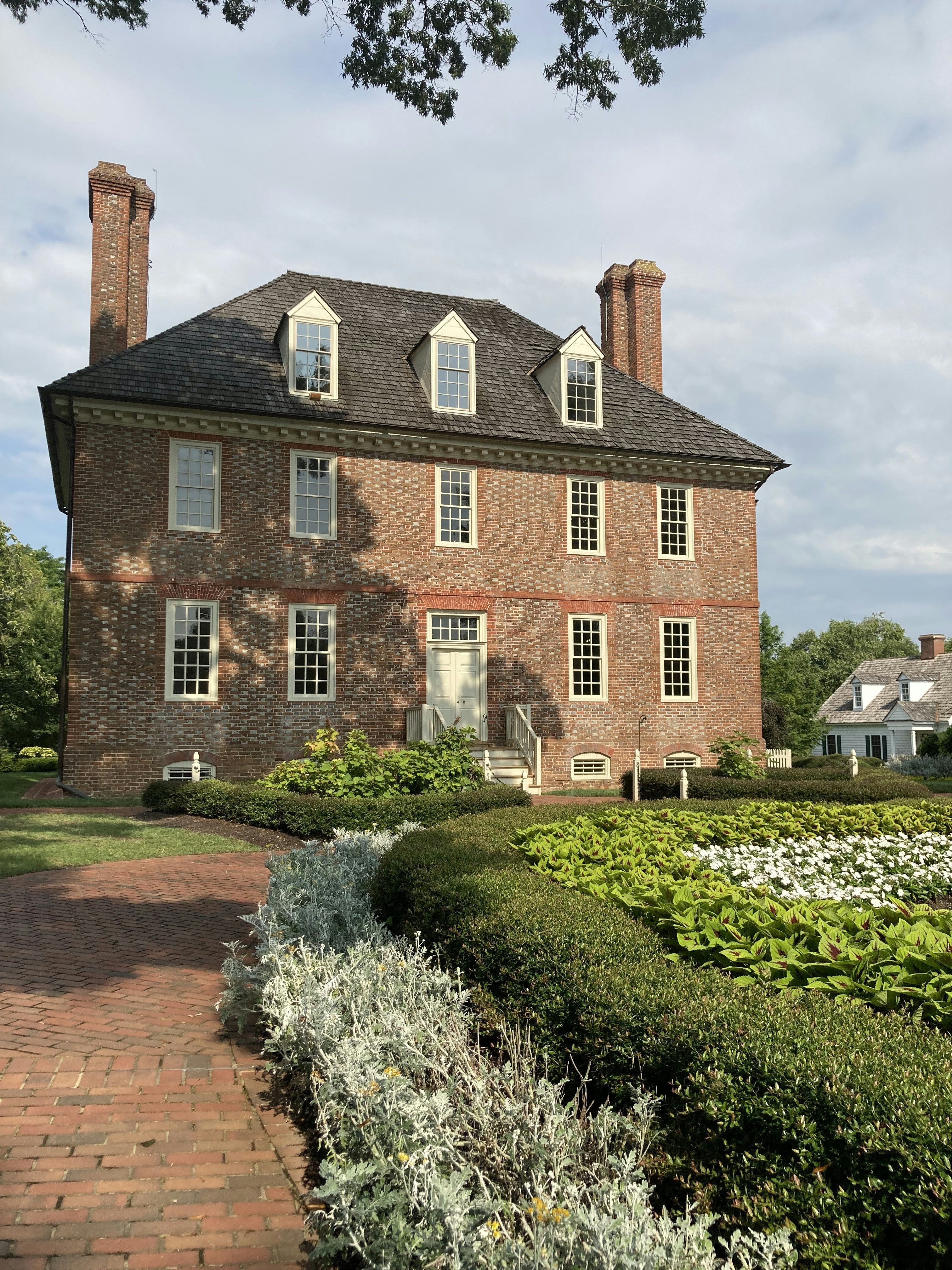 brown brick house near green grass field during daytime