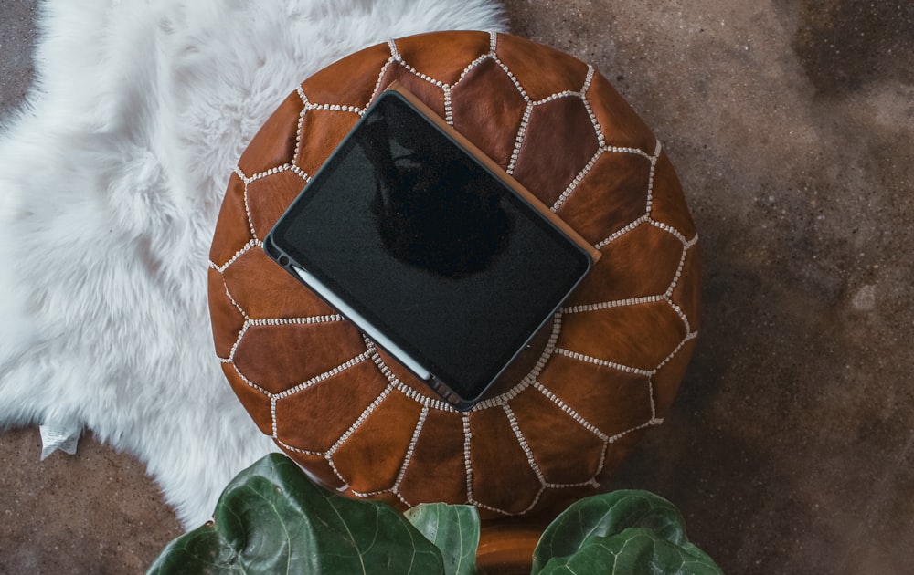 black tablet computer on brown round table