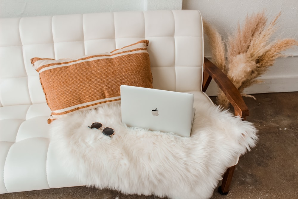 silver macbook on white fur textile