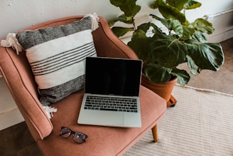 A cozy corner with plants and a laptop displaying the pelvic health blog in forest green and white tones.