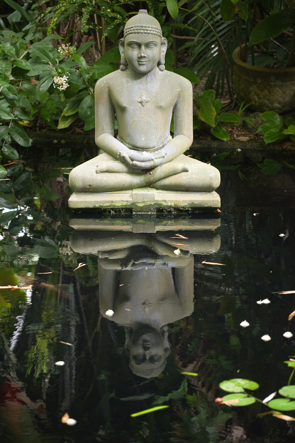 gray concrete statue near green plants