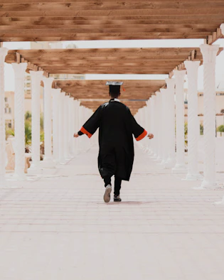 man in black long sleeve shirt and black pants walking on white concrete pathway
