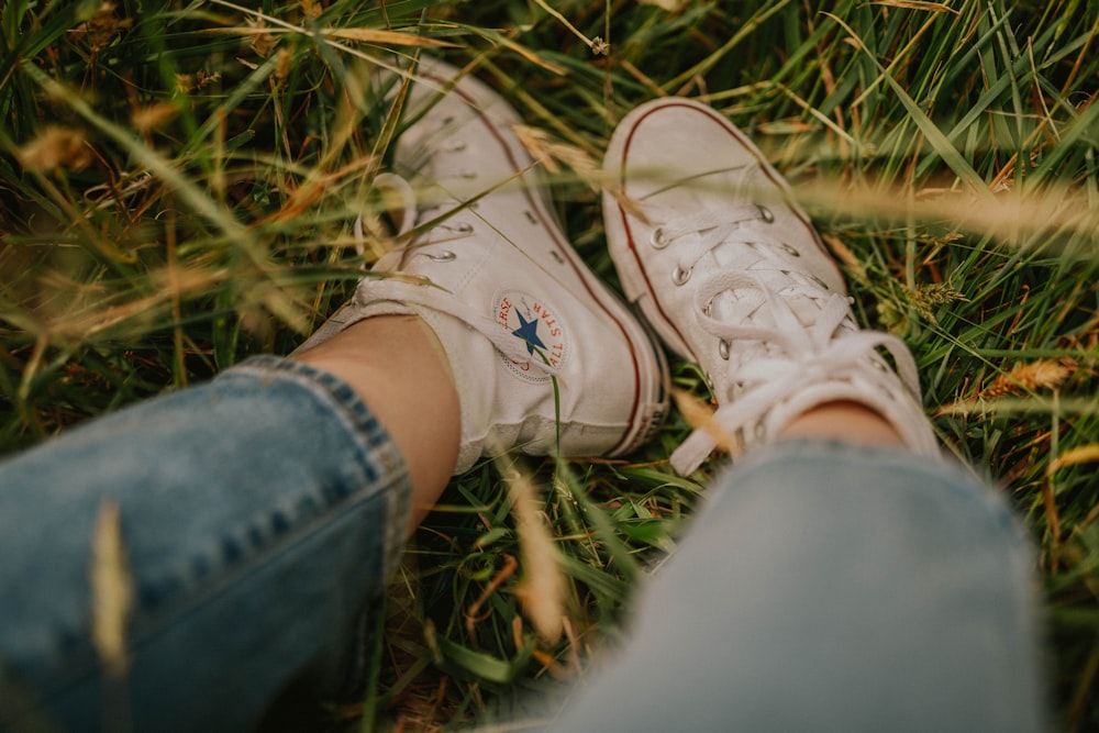 person wearing white converse all star high top sneakers