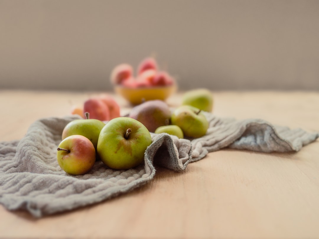 green and red apples on gray textile