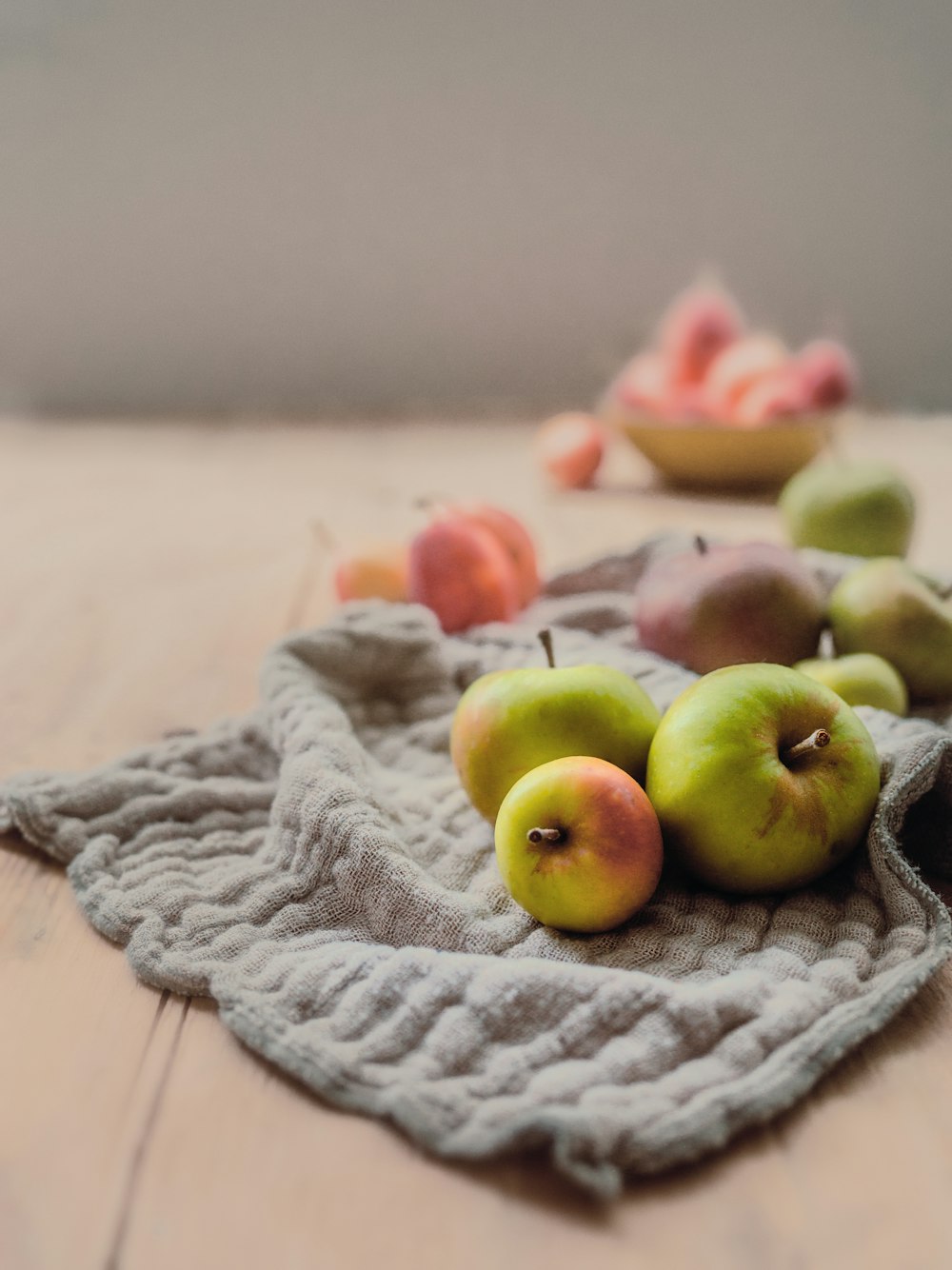 green and red apples on gray textile