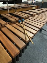 Close-up of a marimba with mallets striking wooden bars in mid-motion.