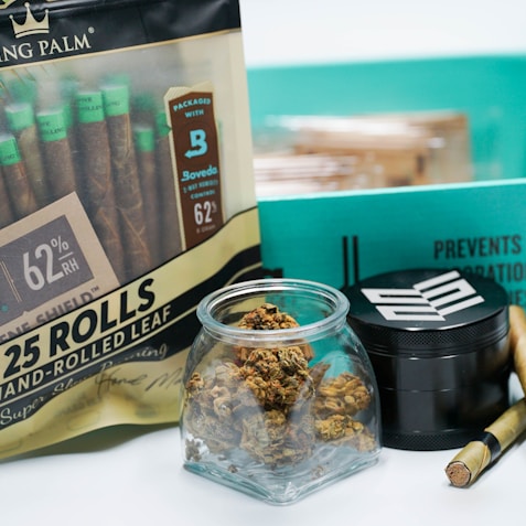 a bag of marijuana next to a container of cigarettes