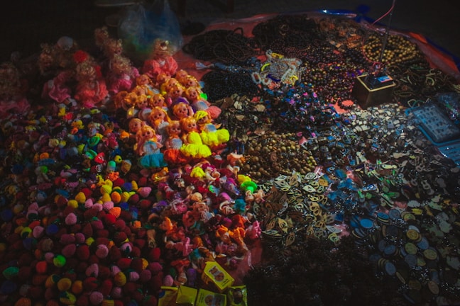 Display of custom amulets and flags featuring Mikkie™ characters arranged artfully on a wooden table.