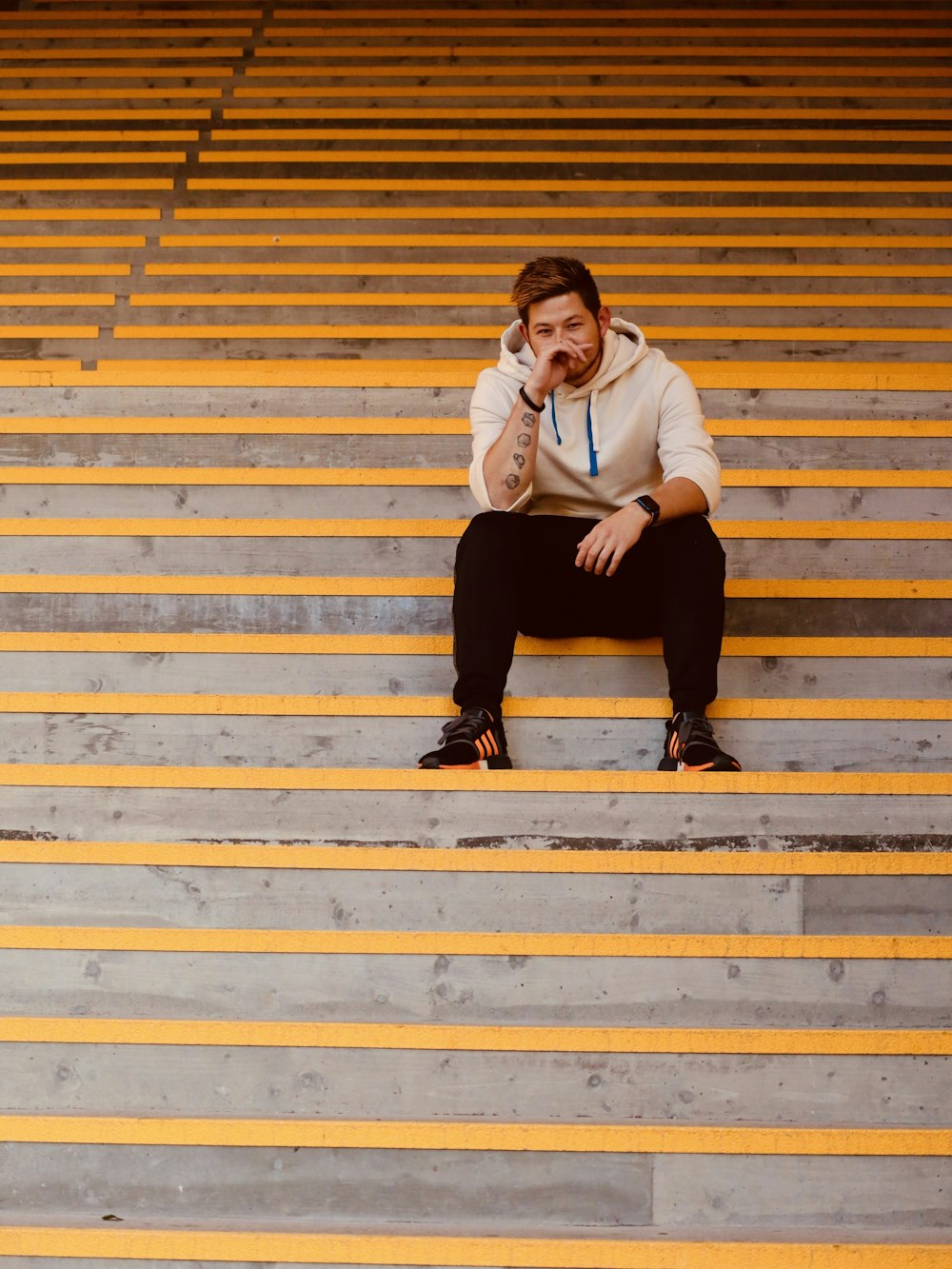 man in white long sleeve shirt sitting on yellow and white staircase