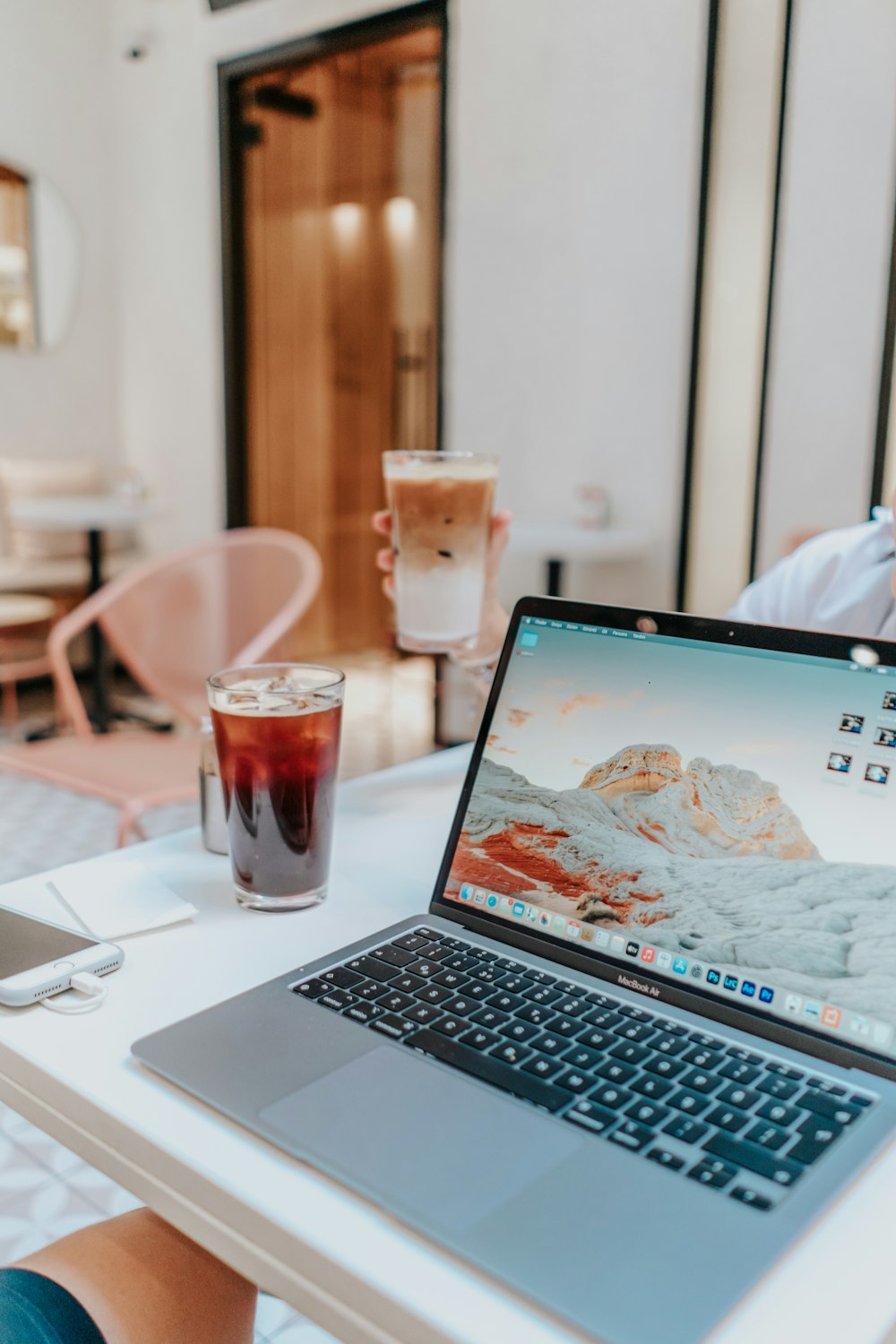 macbook pro beside clear drinking glass on white table