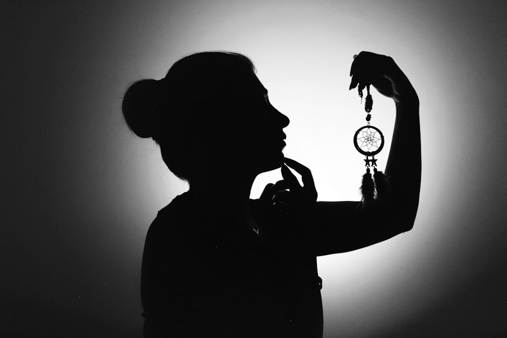 silhouette of man holding magnifying glass