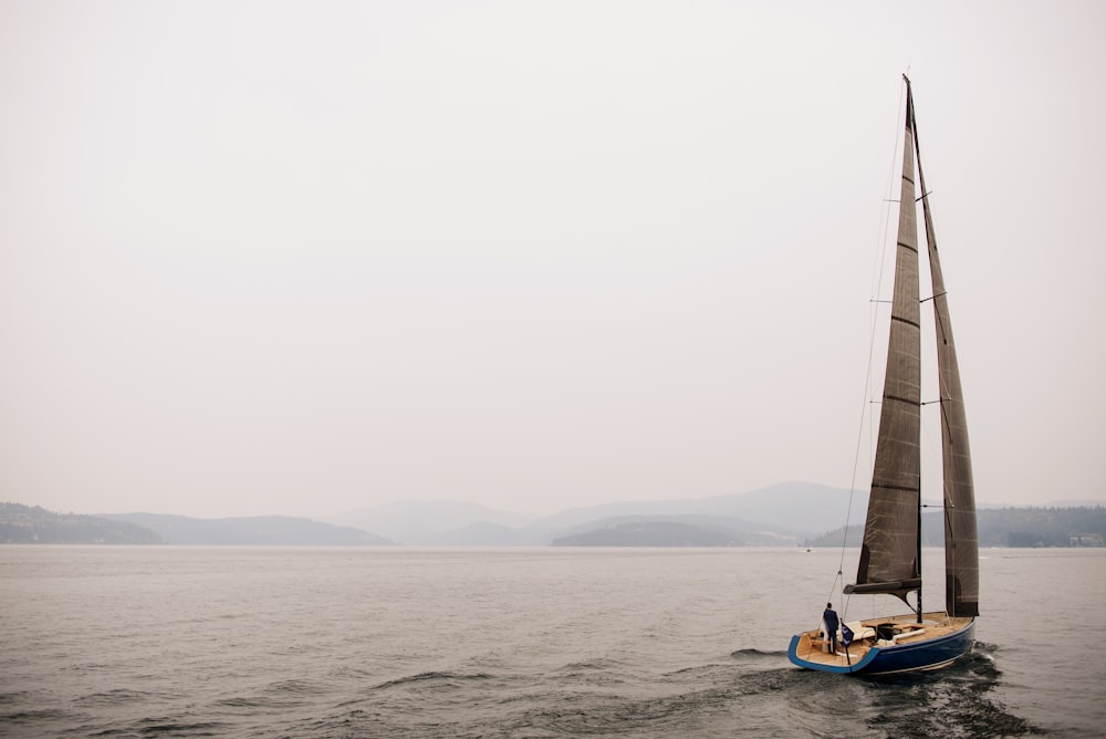 white and blue sailboat on sea during daytime