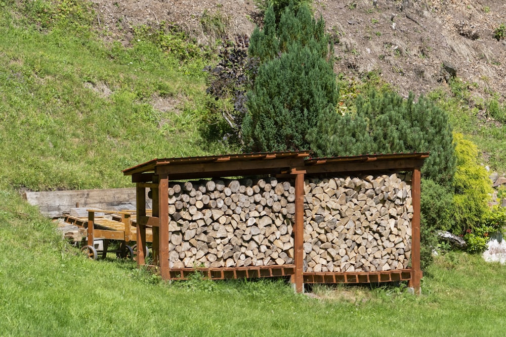 a pile of logs sitting next to a wooden bench