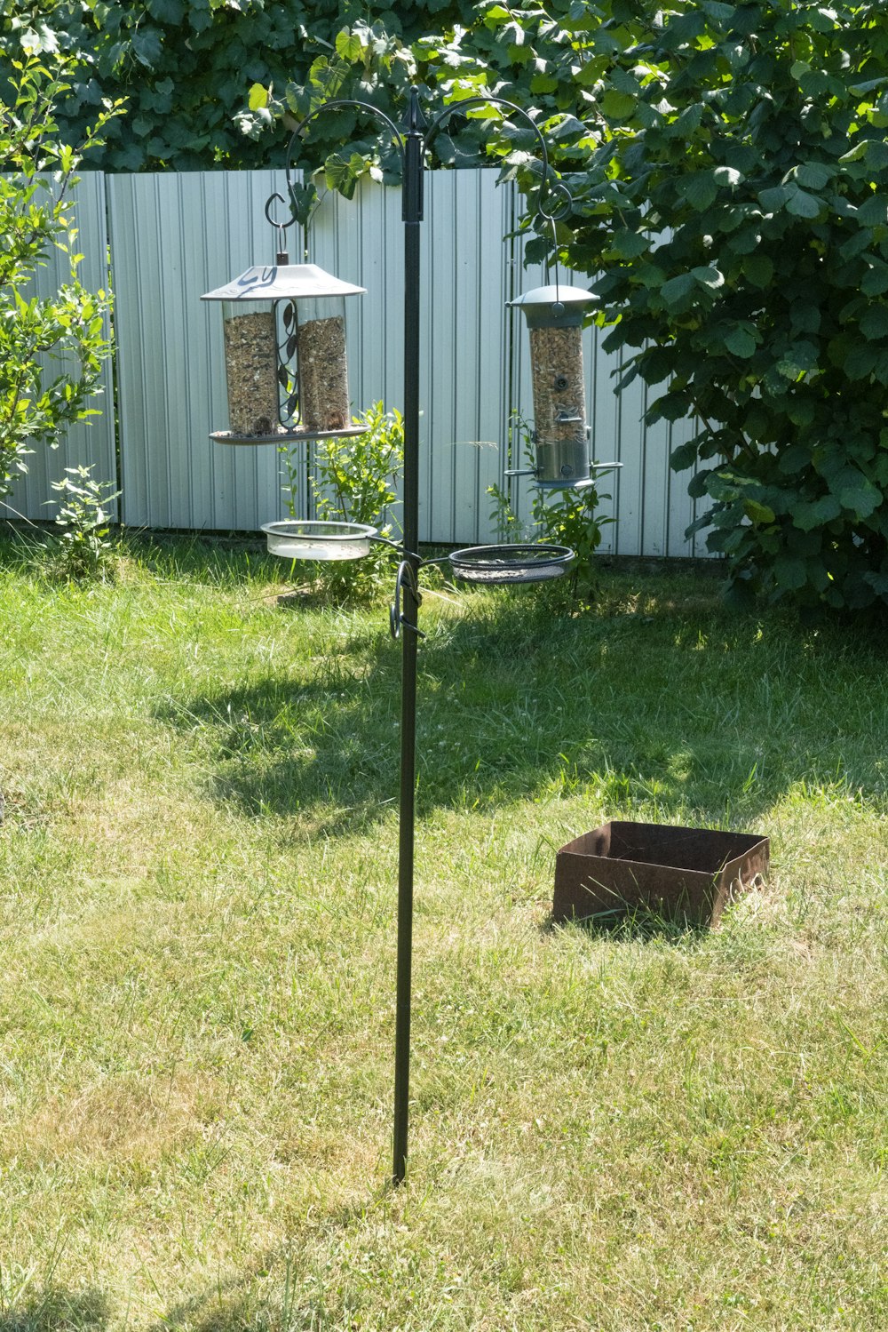 a bird feeder in the middle of a yard