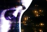 A close-up of a face with dramatic lighting, emphasizing the eye and forehead. The image features a futuristic, abstract effect with sparkles and glowing lights scattered across a dark background.
