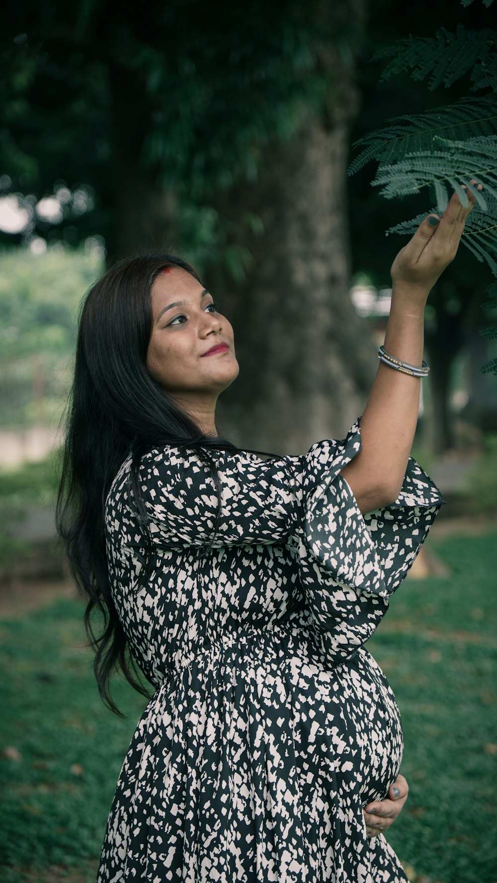 woman in black and white long sleeve shirt standing on green grass field during daytime