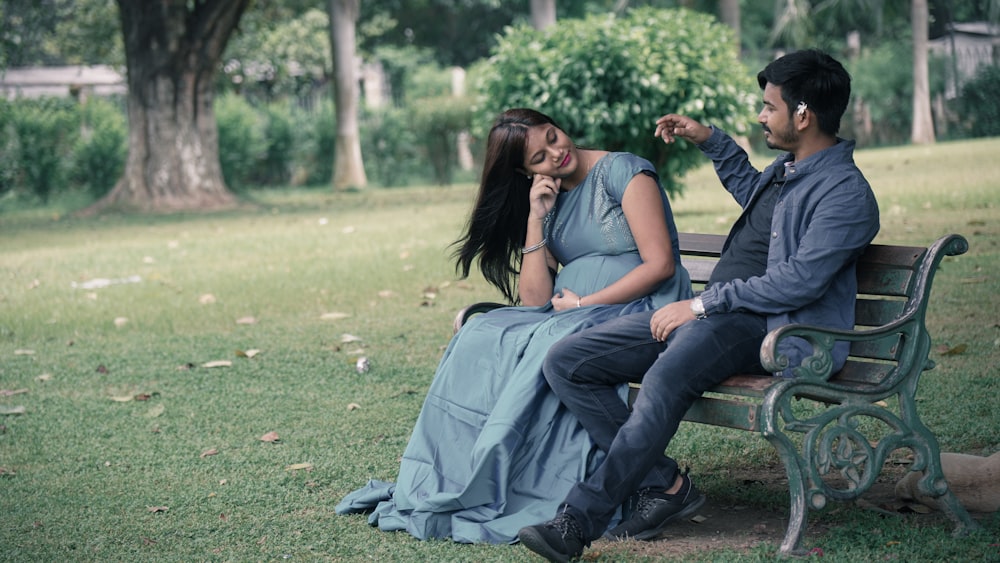 man and woman sitting on green grass field during daytime