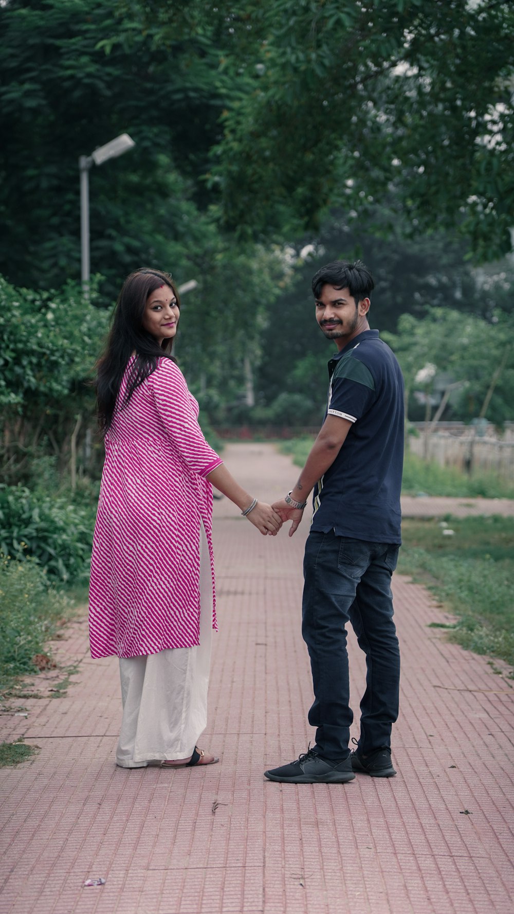 man in black t-shirt holding woman in pink and white dress